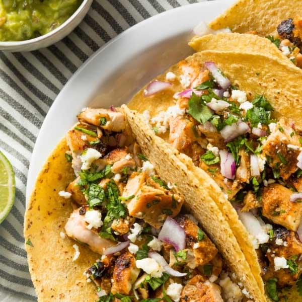 Chicken tikka tacos with bell peppers, onions, corn and spring onions on top. Made with Kissan Tikka Masala