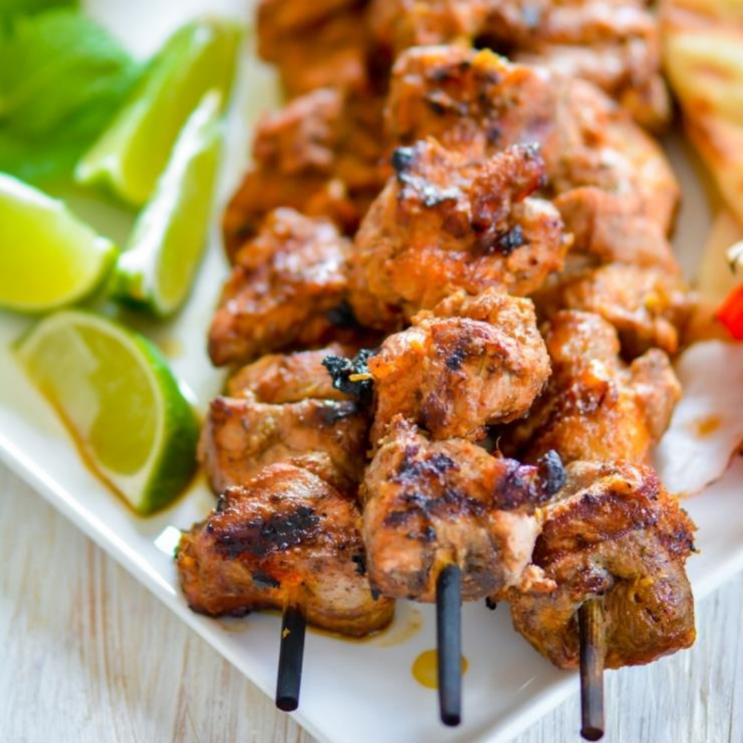 Chicken tikka skewers with lemon wedges