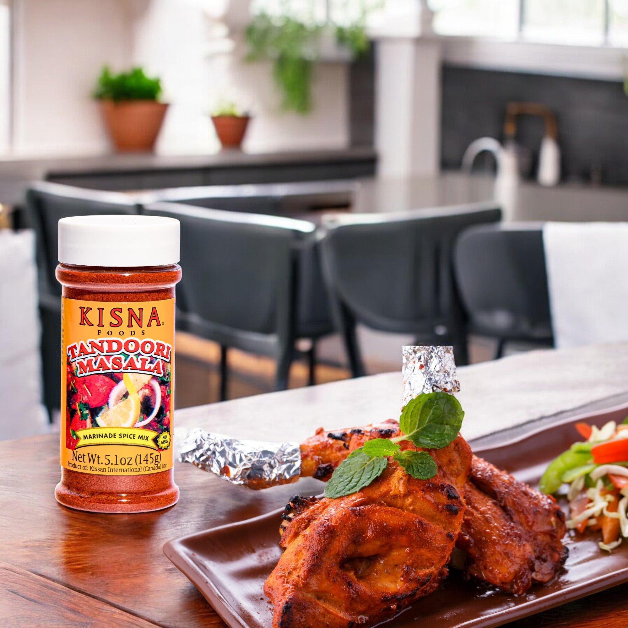 A bottle of KISNA TANDOORI MASALA 145 g with tandoori chicken in the side
